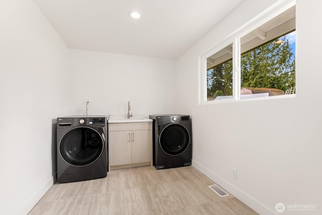 laundry room featuring a sink, visible vents, washer / clothes dryer, and cabinet space