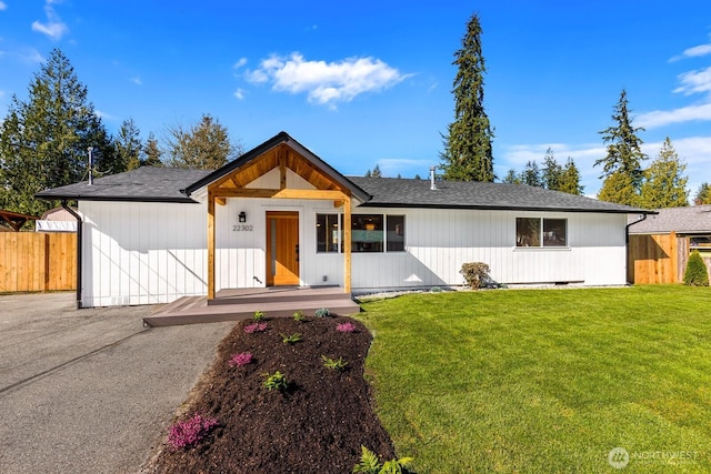 view of front of house with a front lawn and fence