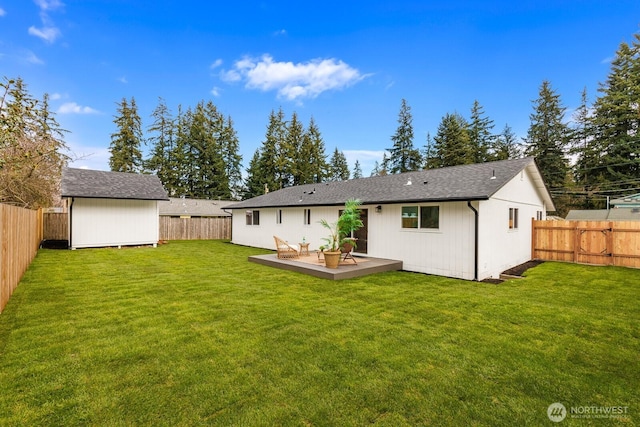 back of house with a deck, an outbuilding, and a fenced backyard