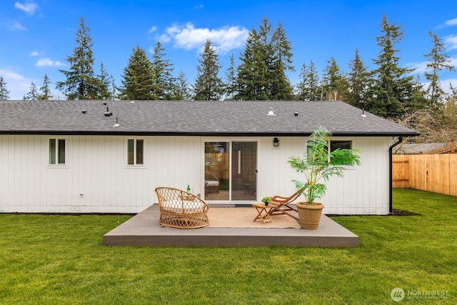 back of property featuring a patio, fence, a lawn, and a shingled roof