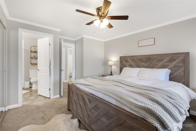 carpeted bedroom with crown molding, ensuite bathroom, ceiling fan, and a closet