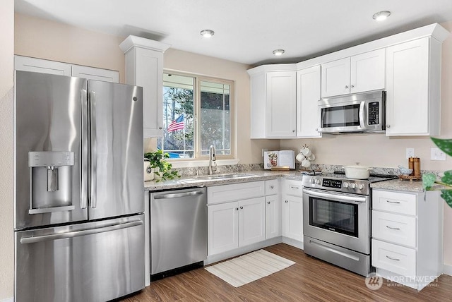 kitchen with stainless steel appliances, sink, and white cabinets