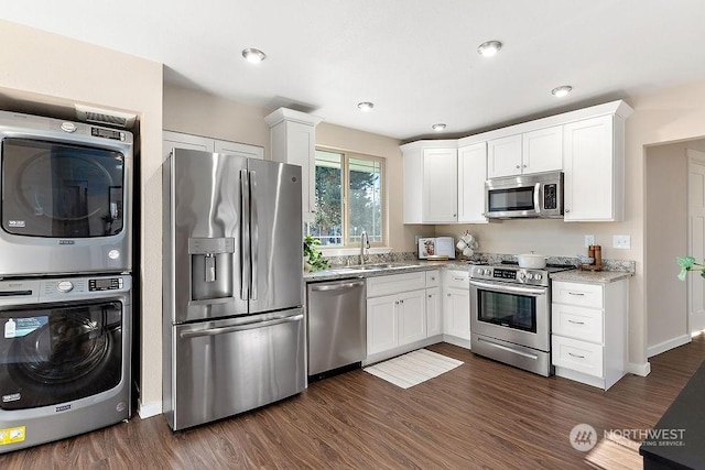 kitchen featuring white cabinetry, sink, stainless steel appliances, and stacked washing maching and dryer