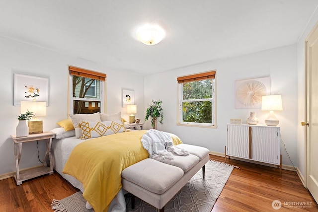 bedroom with baseboards and wood finished floors