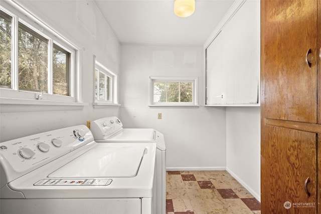 clothes washing area featuring cabinets and washing machine and clothes dryer