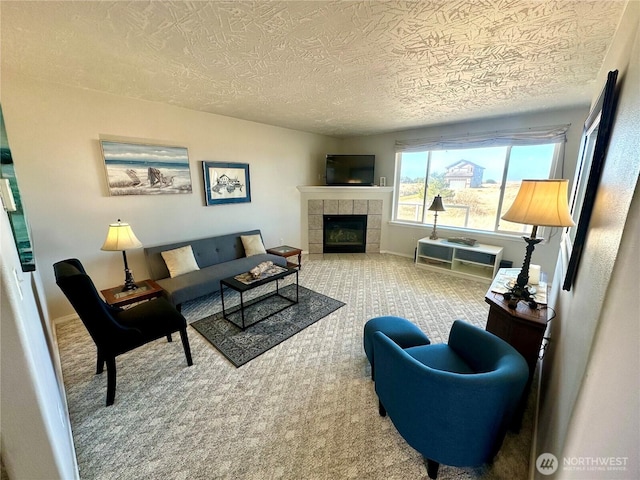 carpeted living area featuring a tile fireplace, a textured ceiling, and baseboards