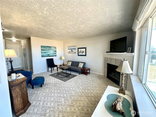 living area featuring carpet floors, a tile fireplace, and baseboards