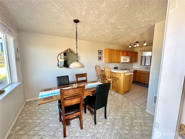 dining space with baseboards, visible vents, a textured ceiling, and light tile patterned flooring