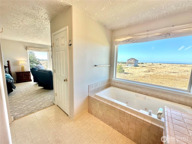 ensuite bathroom with a whirlpool tub, a textured ceiling, ensuite bath, and tile patterned floors