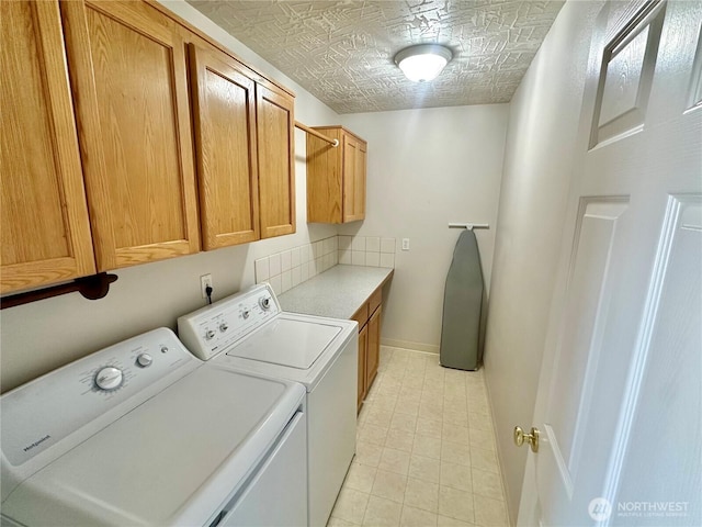 laundry room with cabinet space, baseboards, and separate washer and dryer