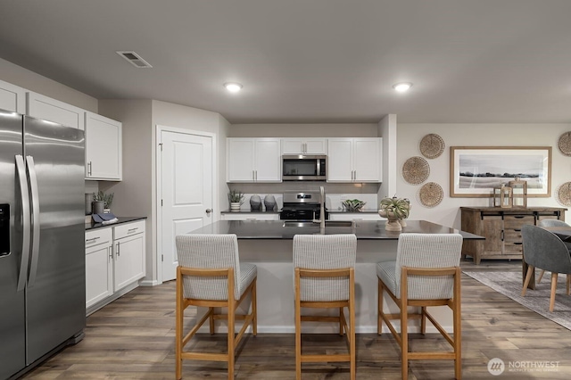 288 Wind River Ct, Chehalis, WA 98532 - kitchen with stainless steel appliances, white cabinetry, sink, and a kitchen bar