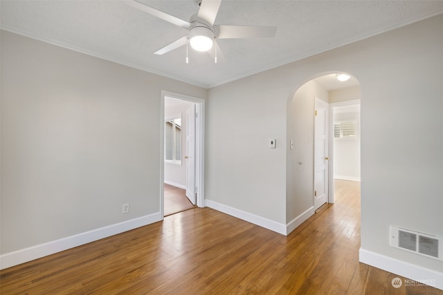 empty room featuring hardwood / wood-style floors, crown molding, a textured ceiling, and ceiling fan