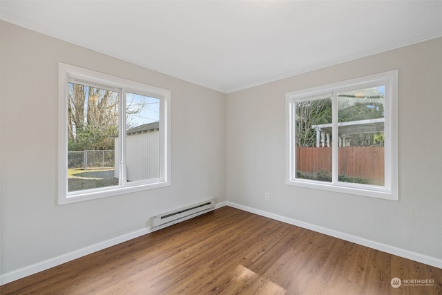 spare room with hardwood / wood-style flooring and a baseboard heating unit