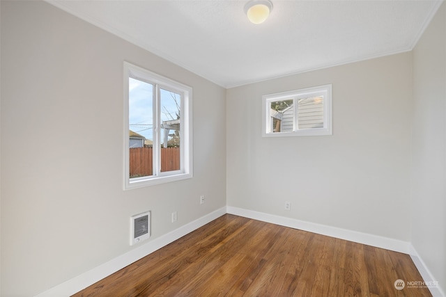 spare room featuring a healthy amount of sunlight and hardwood / wood-style floors