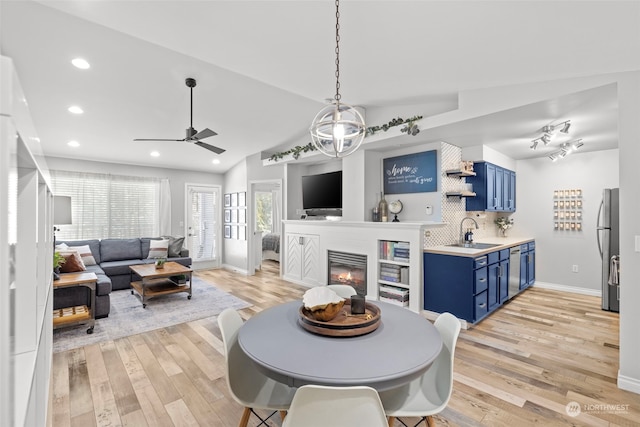 dining area featuring lofted ceiling, indoor wet bar, light hardwood / wood-style floors, and ceiling fan