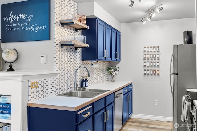 kitchen featuring sink, backsplash, stainless steel appliances, blue cabinets, and light wood-type flooring