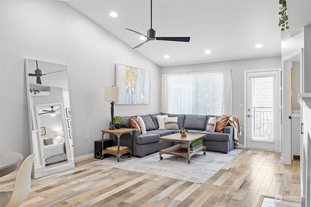 living room featuring light hardwood / wood-style flooring, ceiling fan, and vaulted ceiling