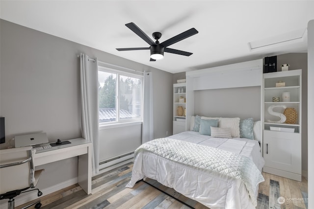 bedroom featuring a baseboard heating unit, light hardwood / wood-style floors, and ceiling fan