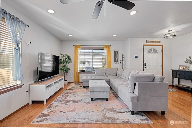 living room with light hardwood / wood-style floors and ceiling fan