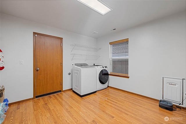 laundry area with light wood-type flooring and independent washer and dryer