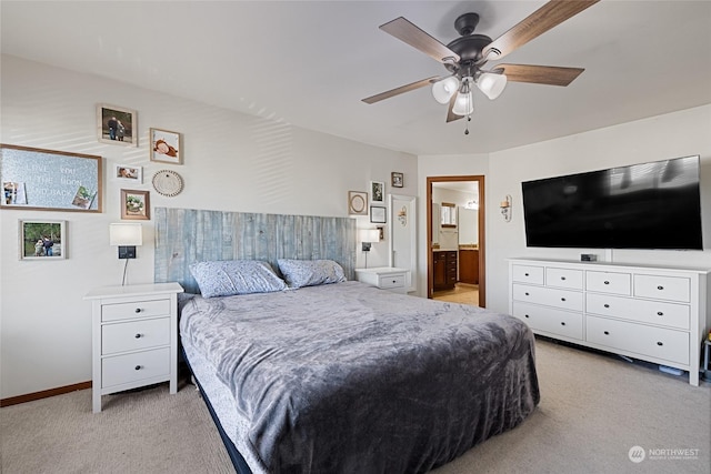 bedroom featuring connected bathroom, light colored carpet, and ceiling fan