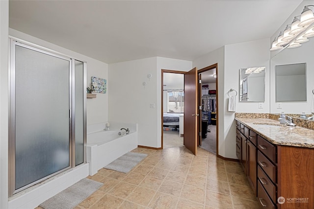 bathroom with vanity and shower with separate bathtub