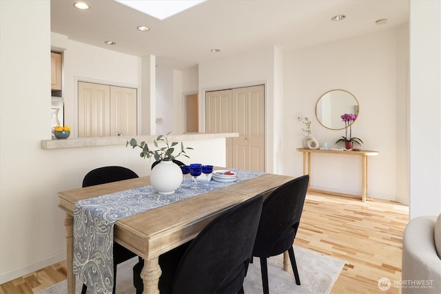 dining room featuring recessed lighting, light wood-type flooring, and baseboards