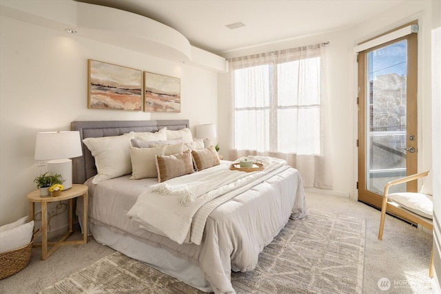 bedroom featuring visible vents, multiple windows, light carpet, and access to exterior