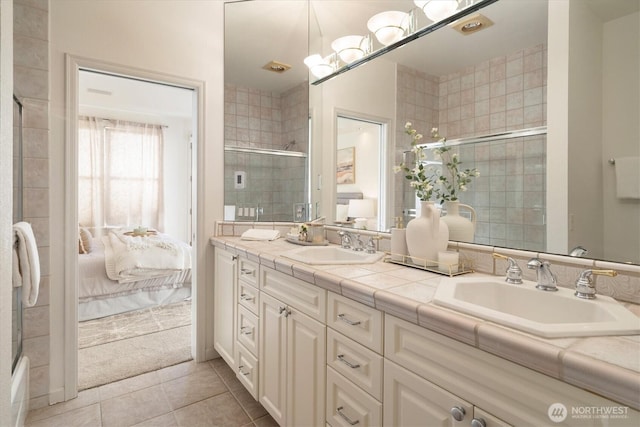 ensuite bathroom featuring ensuite bath, tiled shower, and a sink