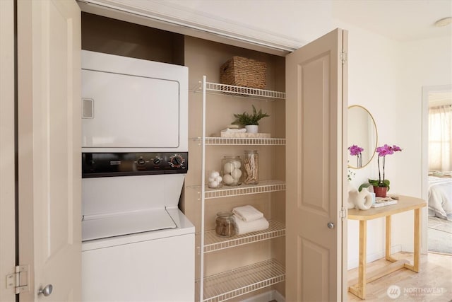 washroom with stacked washer / drying machine and laundry area