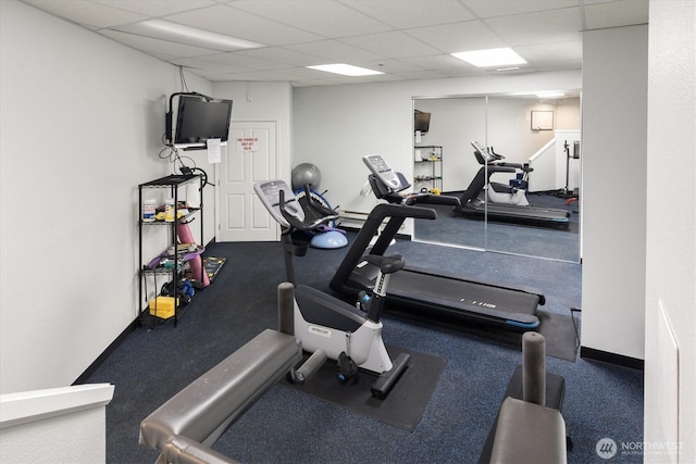 gym with a paneled ceiling and baseboards