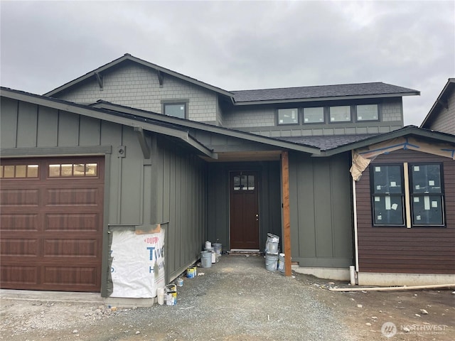 view of front of property featuring an attached garage, board and batten siding, and roof with shingles