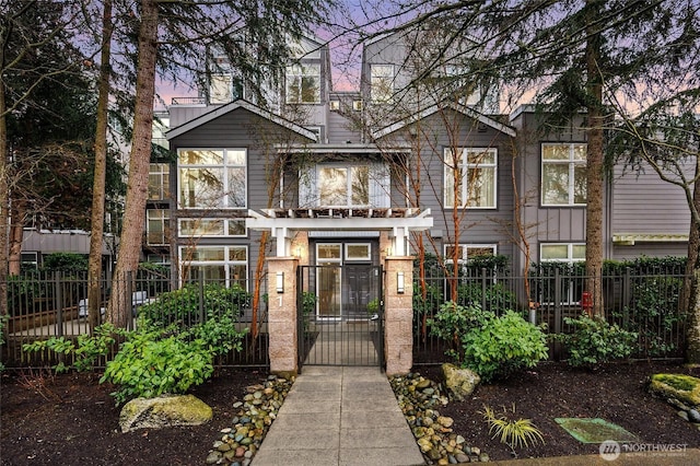 view of front of property with a fenced front yard and a gate