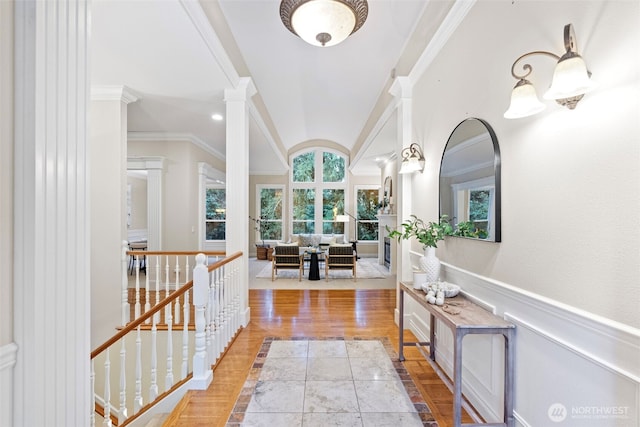 hall with ornamental molding, light hardwood / wood-style floors, and ornate columns