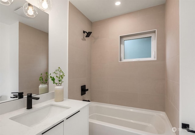 bathroom with tiled shower / bath and vanity