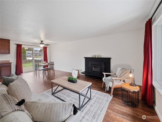 living room featuring hardwood / wood-style floors, a brick fireplace, and ceiling fan