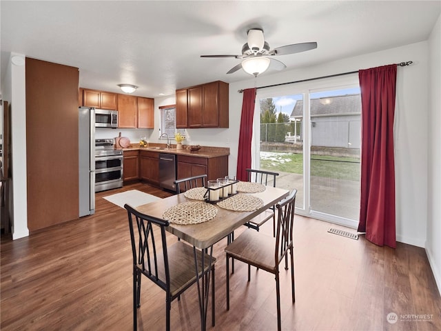 dining room featuring dark hardwood / wood-style flooring, sink, and ceiling fan