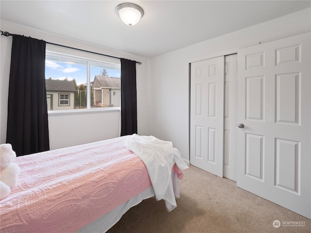 bedroom with light carpet and a closet