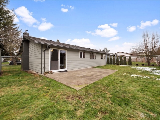 rear view of property with a yard and a patio