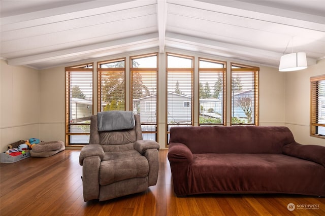 living room with hardwood / wood-style floors, vaulted ceiling with beams, and a healthy amount of sunlight