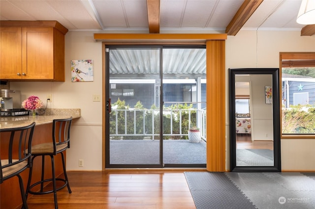 entryway featuring dark hardwood / wood-style flooring, ornamental molding, and beamed ceiling