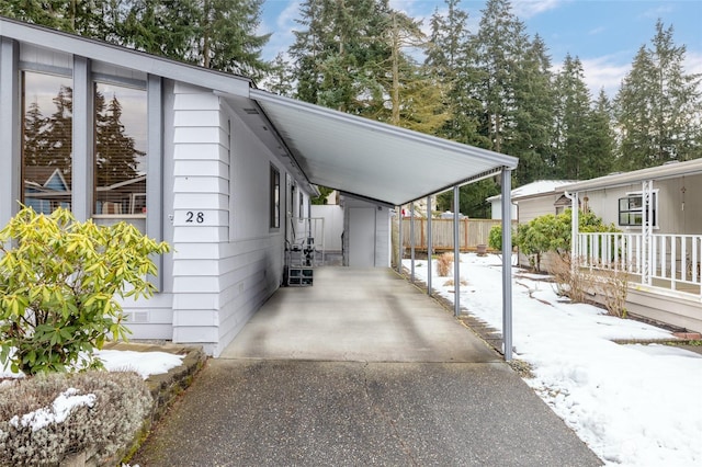 snow covered property featuring a carport