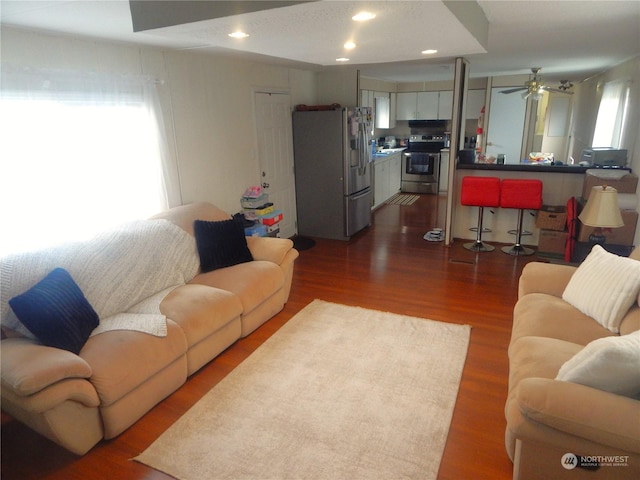 living room with ceiling fan and dark hardwood / wood-style flooring