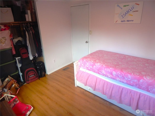 bedroom with wood-type flooring and a closet