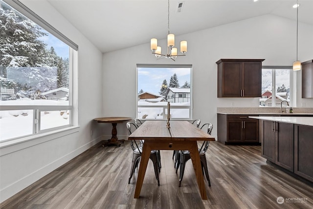 dining area with lofted ceiling, dark hardwood / wood-style floors, a chandelier, and sink