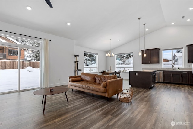 living room featuring dark wood-type flooring, high vaulted ceiling, sink, and an inviting chandelier