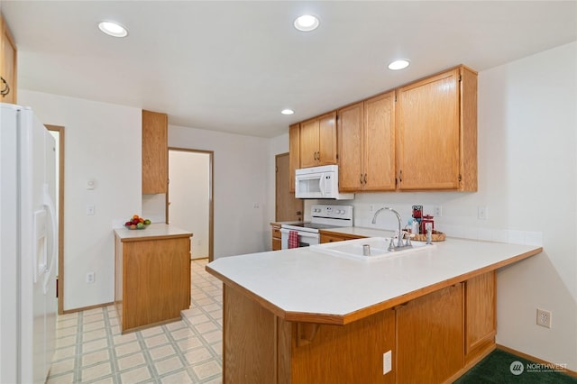 kitchen featuring sink, white appliances, and kitchen peninsula