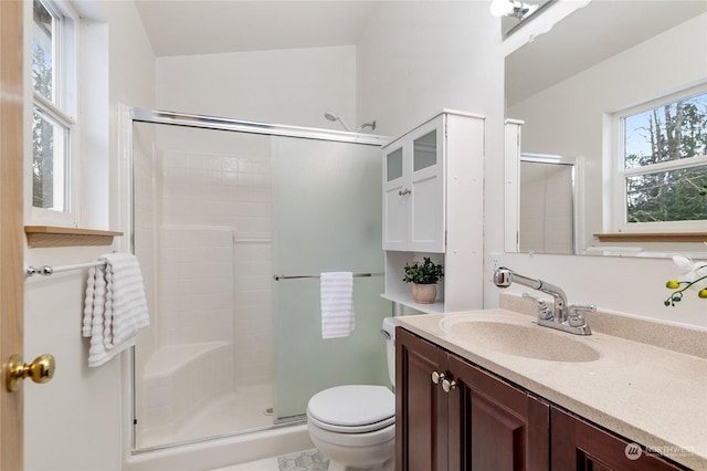 bathroom with walk in shower, vanity, and toilet