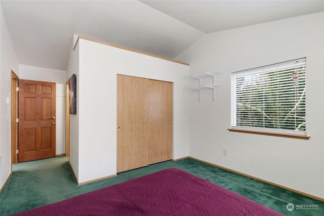 unfurnished bedroom featuring lofted ceiling, dark carpet, and a closet