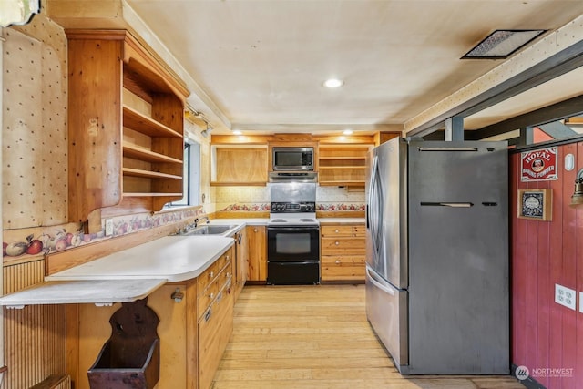 kitchen with tasteful backsplash, stainless steel appliances, sink, and light wood-type flooring